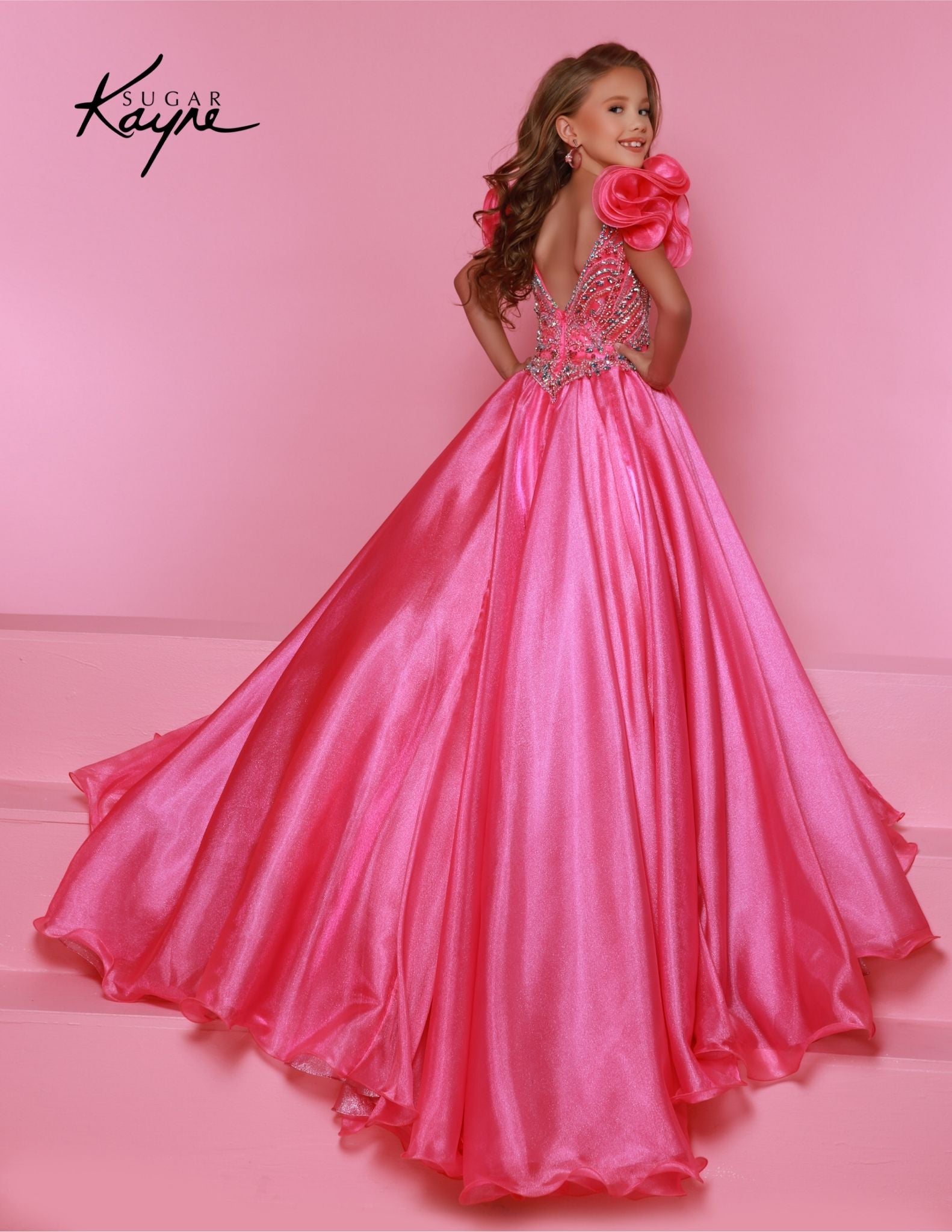 Bring out her inner beauty with this Sugar Kayne C334 Girls Pageant Dress. This luxurious dress is made from iridescent organza and features a sweetheart neckline and long ball gown skirt. Perfect for any special occasion. Transform into a twinkling starlet with this Metallic Organza Gown. The beaded bodice adds a touch of sparkle to this enchanting ensemble. The delicate ruffle sleeves create a charming look!