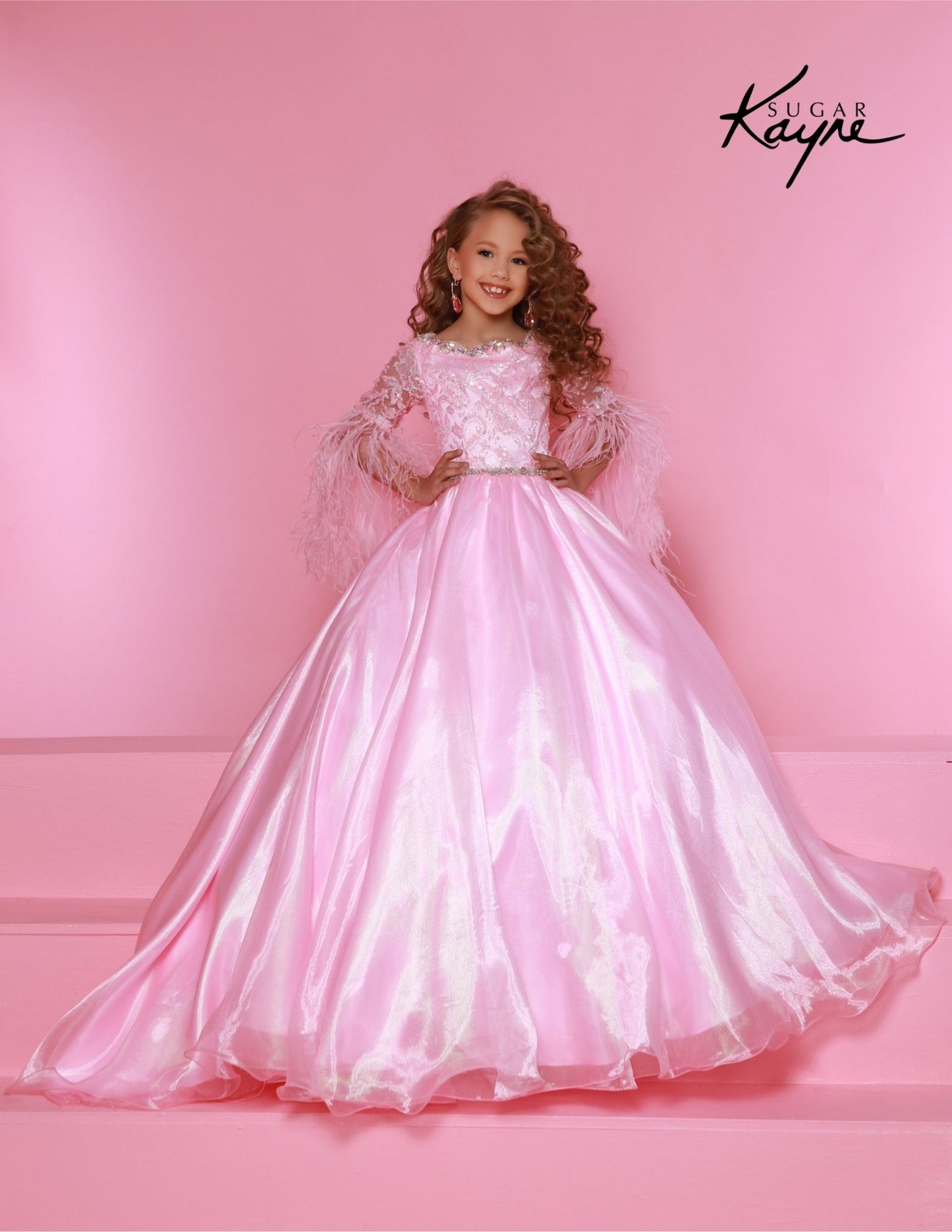 The Sugar Kayne C338 Preteen Pageant Dress is an elegant A-line ballgown featuring sequin and feather sleeves. Featuring the highest quality materials, this dress is perfect for special occasions and is sure to make your child feel like a princess. Experience twinkling elegance in this Metallic Organza Ballgown. The feathered sleeves are designed to make you feel like royalty.