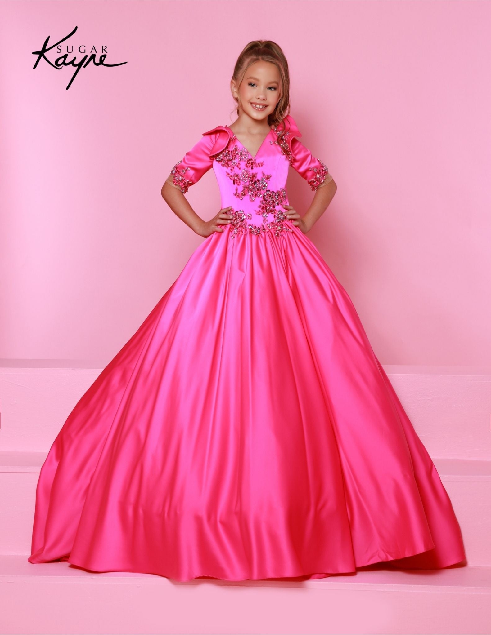 This beautiful Sugar Kayne C343 Pageant Dress offers a stunning A-line silhouette with a unique plunging V neckline adorned with dazzling crystals. Crafted from luxurious satin fabric, this dress is perfect for the little girl who wants to shine. Embrace the glamour of a storybook princess. Our Stretch Crepe Back Satin ballgown is sure to radiate grace of a true princess!