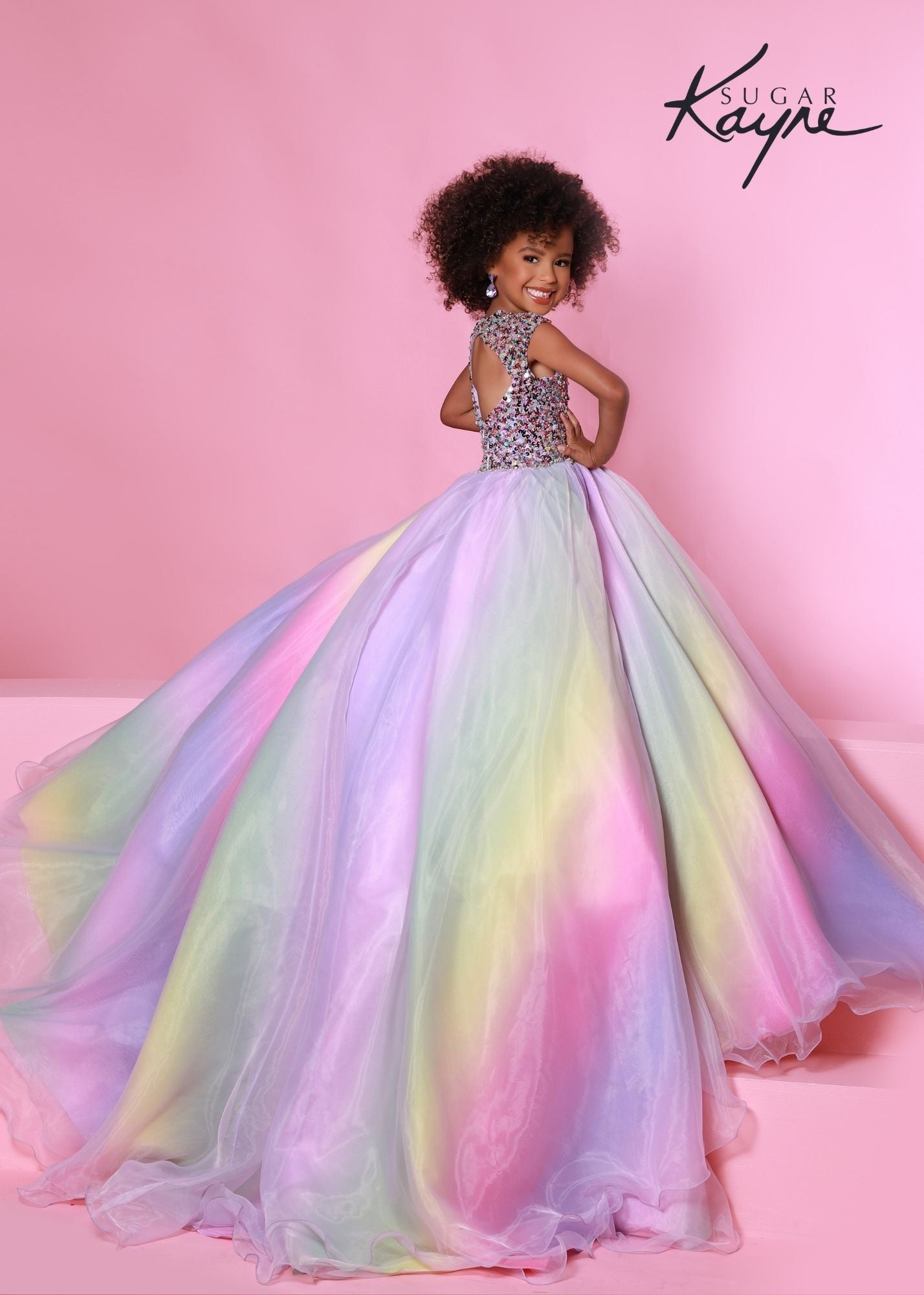 Sugar Kayne C180 This Rainbow Girls Pageant Dress is a long multi colored dress in the design of a rainbow.  The spectacular kids ballgown has small cap sleeves and a crew neckline covered in multi sequins with a cutout back.  It has an organza long rainbow skirt with an extravagant long train in the back.  Enjoy this beautiful dress while gliding over the stage. Ombre Rainbow 
