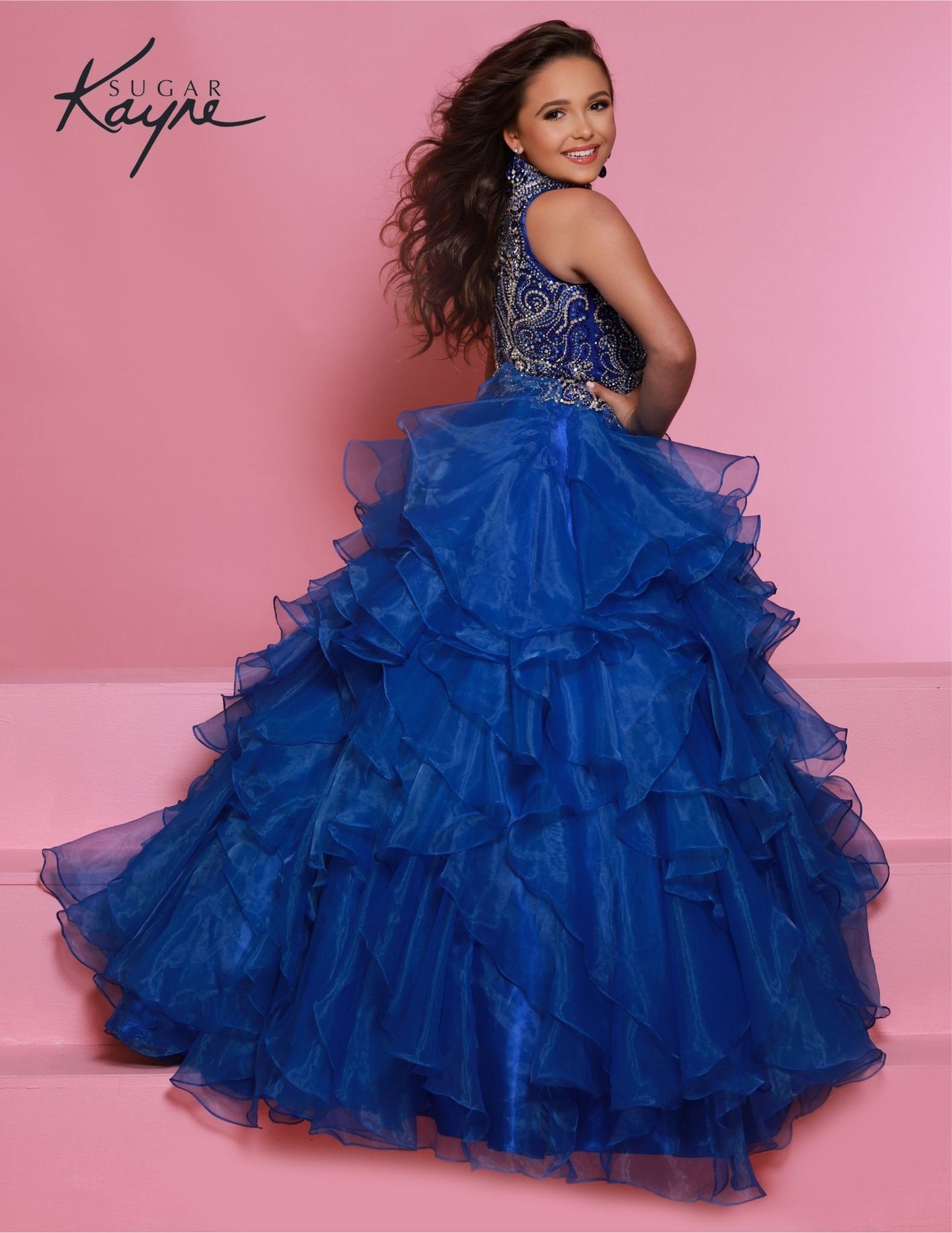 Sugar Kayne C326 royal blue is the perfect pageant dress for young girls and preteens, featuring a ruffled long skirt, high neckline, and crystal bodice with sleeveless design.