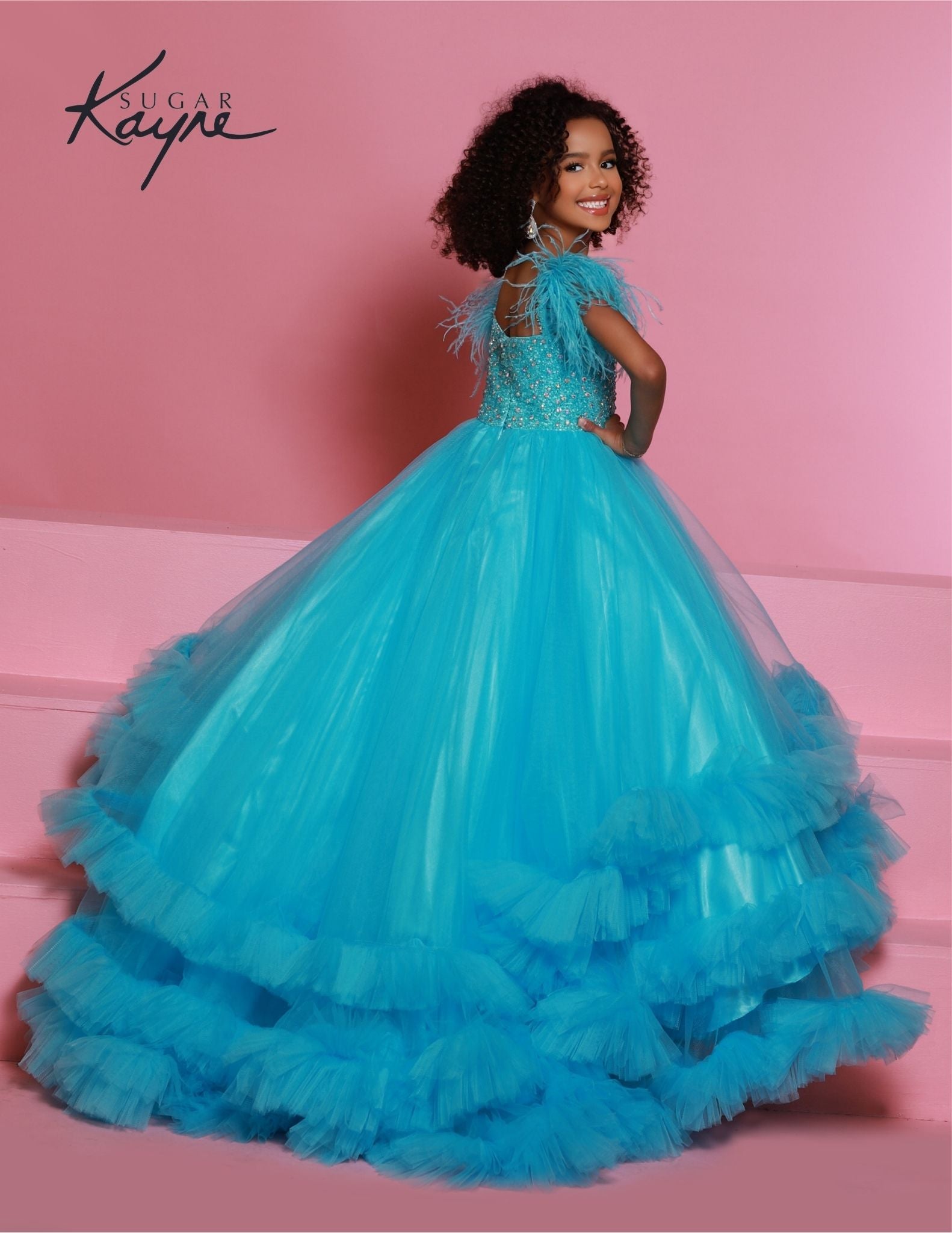 Sugar Kayne C327 features a fashionable aqua pageant dress for girls and preteens, complete with feather straps, a tiered ruffle bottom, and a crystal stone bodice.