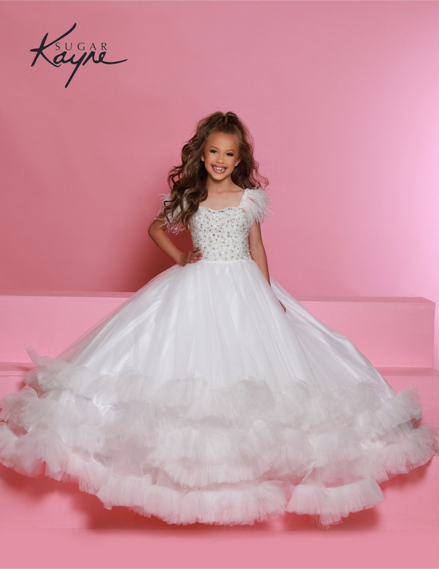 Sugar Kayne C327 features a fashionable white pageant dress for girls and preteens, complete with feather straps, a tiered ruffle bottom, and a crystal stone bodice.