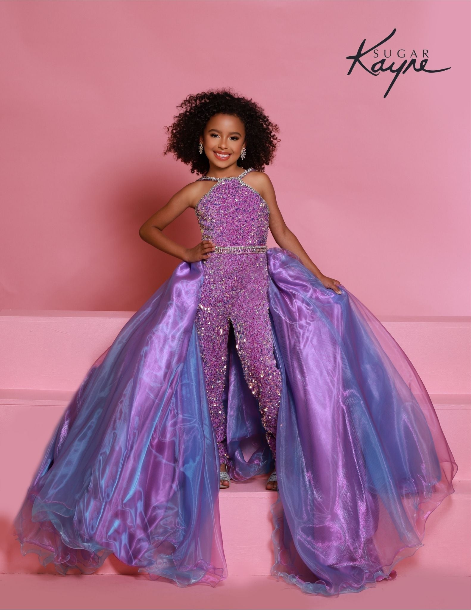 Sugar Kayne C332 offers a unique sequined jumpsuit style for girls and preteens with its fun fashion detachable overskirt and halter neckline on orchid stretch sequin velvet. 