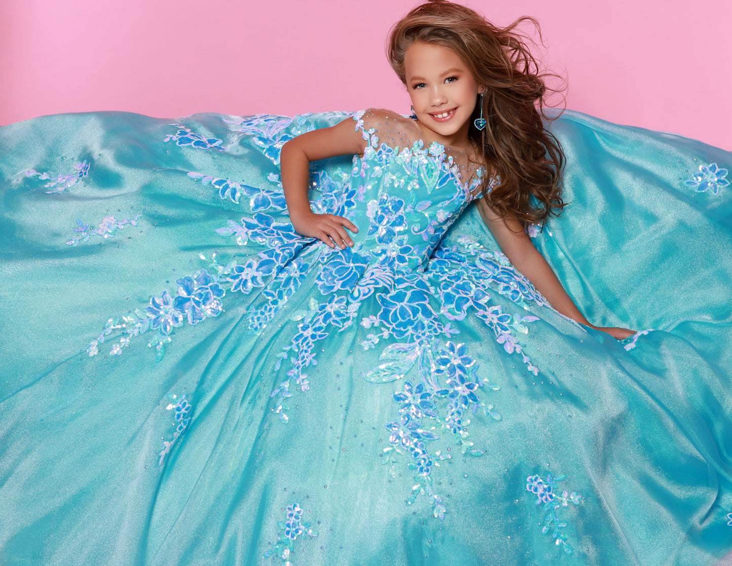 Look sharp and sparkly in the Sugar Kayne C336 long pageant dress. Constructed with a luxurious sequin mesh material, this dress ensures a glamorous touch while remaining lightweight and comfortable. The perfect choice for any event, its full-length skirt provides an elegant look that is sure to make heads turn.&nbsp;Dazzle and delight in our Sequin Mesh and Shimmer Organza Ballgown! This enchanting gown will twinkle and shine at any pageant.

Color:&nbsp;Blue Raspberry, Cotton Candy, Tangerine

Size:&nbsp;