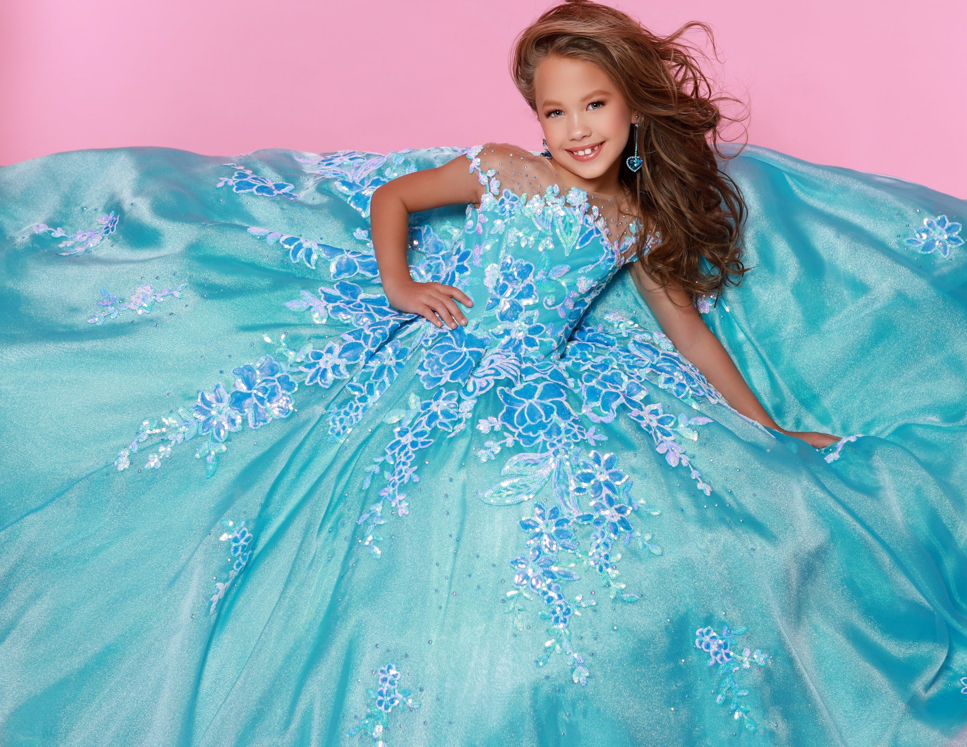 Look sharp and sparkly in the Sugar Kayne C336 long pageant dress. Constructed with a luxurious sequin mesh material, this dress ensures a glamorous touch while remaining lightweight and comfortable. The perfect choice for any event, its full-length skirt provides an elegant look that is sure to make heads turn.&nbsp;Dazzle and delight in our Sequin Mesh and Shimmer Organza Ballgown! This enchanting gown will twinkle and shine at any pageant.

Color:&nbsp;Blue Raspberry, Cotton Candy, Tangerine

Size:&nbsp;