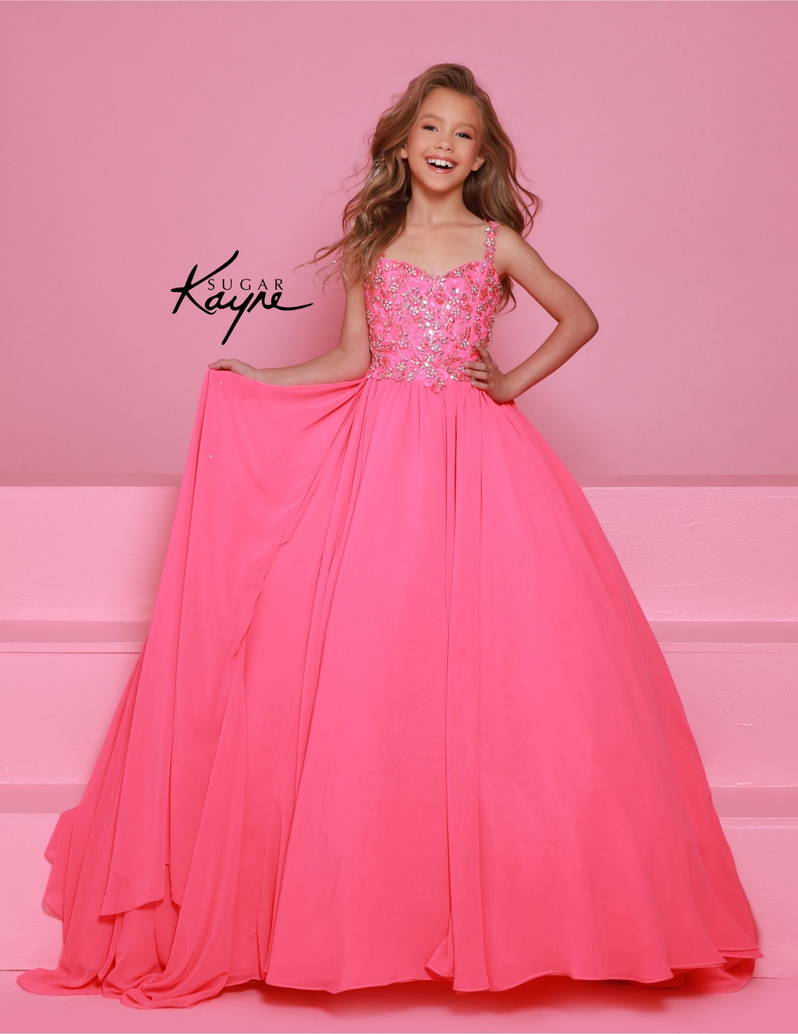 Experience the epitome of grace and sophistication with the Sugar Kayne C368 Chiffon Cape Girls Pageant Dress. Adorned with delicate crystal sequins and a stunning bodice, this ballgown is sure to make a lasting impression. The chiffon cape adds a touch of elegance and the perfect finishing touch. Perfect for teenagers looking for a show-stopping dress. Be simply stunning at your next pageant in this exquisite poly chiffon dress. Designed with beaded straps and a bodice that exudes winner-worthy elegance, i