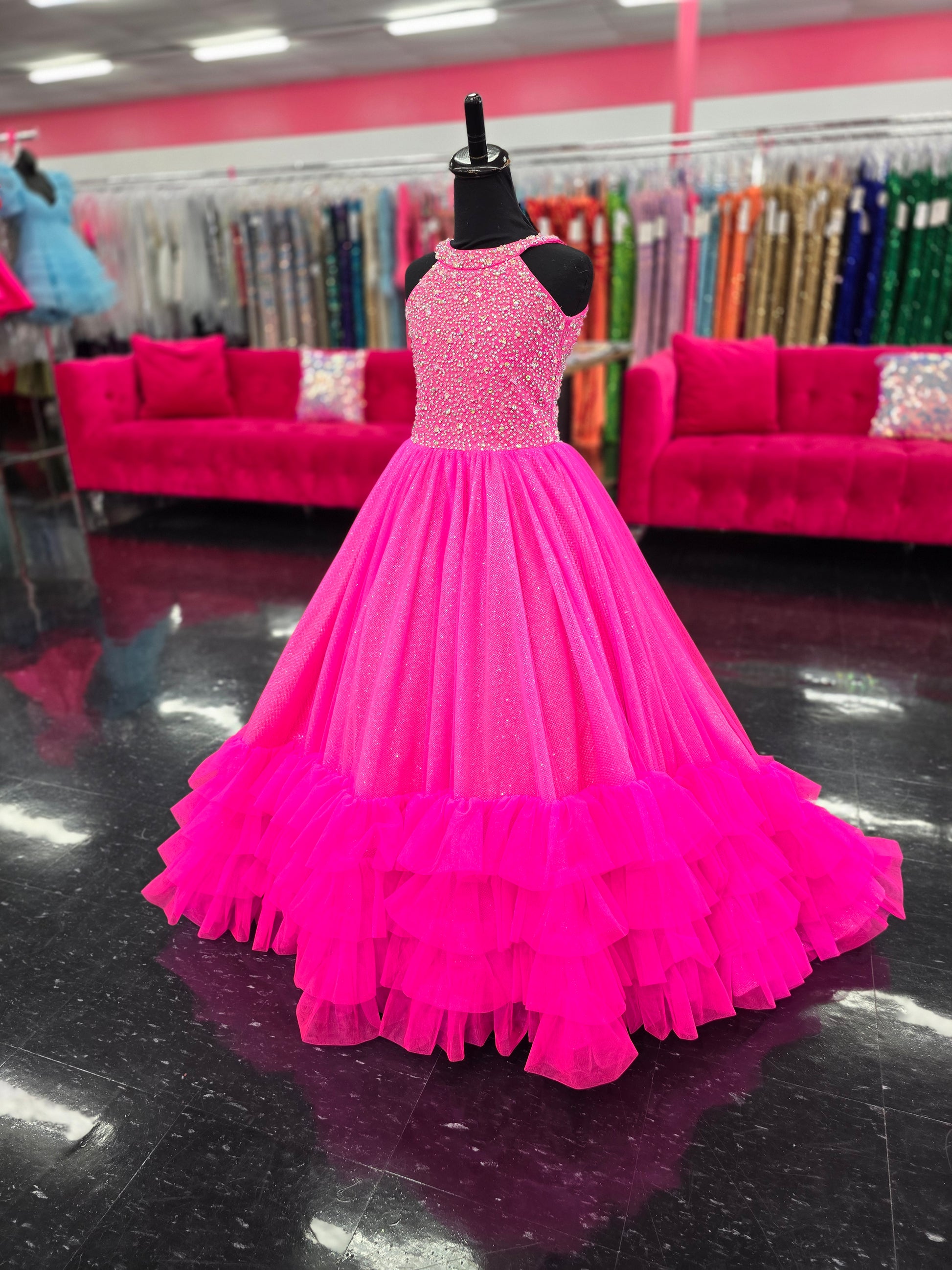 This Tiffany Princess pageant dress (style 13795) features a high neck, crystal embellishments, and a backless corset. The ruffle tulle skirt adds a touch of elegance, while the corset provides a secure fit. Perfect for any pageant girl looking to make a statement on stage.