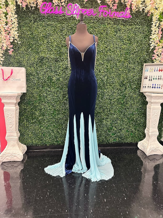 This Johnathan Kayne 2706 gown features a long fitted velvet silhouette with a pleated mermaid skirt and elegant train, designed to enhance your figure with sophisticated flair. The off-the-shoulder sleeves are adorned with a detachable crystal fringe tassel, adding a touch of sparkle and versatility. Perfect for pageants or formal events, This velvet dress combines classic elegance with modern detailing for a standout look.

Size: 4

Color: Navy/Aqua