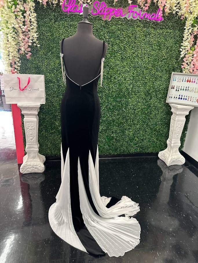 This Johnathan Kayne 2706 gown features a long fitted velvet silhouette with a pleated mermaid skirt and elegant train, designed to enhance your figure with sophisticated flair. The off-the-shoulder sleeves are adorned with a detachable crystal fringe tassel, adding a touch of sparkle and versatility. Perfect for pageants or formal events, This velvet dress combines classic elegance with modern detailing for a standout look.

Size: 4

Color: Black/White