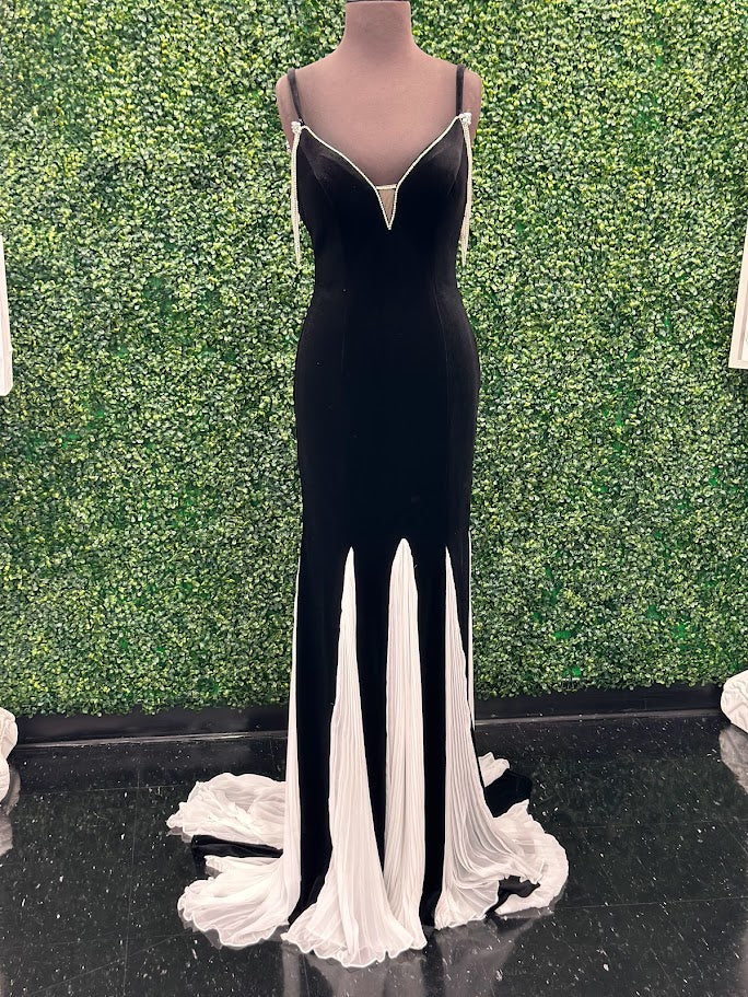 This Johnathan Kayne 2706 gown features a long fitted velvet silhouette with a pleated mermaid skirt and elegant train, designed to enhance your figure with sophisticated flair. The off-the-shoulder sleeves are adorned with a detachable crystal fringe tassel, adding a touch of sparkle and versatility. Perfect for pageants or formal events, This velvet dress combines classic elegance with modern detailing for a standout look.

Size: 4

Color: Black/White