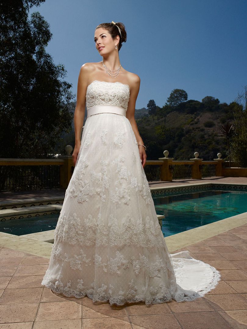 Casablanca Bridal 1900  "Classic Becomes You" in this strapless A-line silhouette. The beaded Chantilly Lace overlay scallops on the neckline with elaborate hand-embroidered designs and crystals on the bodice. A stunning empire waistline wrapped in Luxe satin and scalloped semi-chapel train makes this gown timeless.