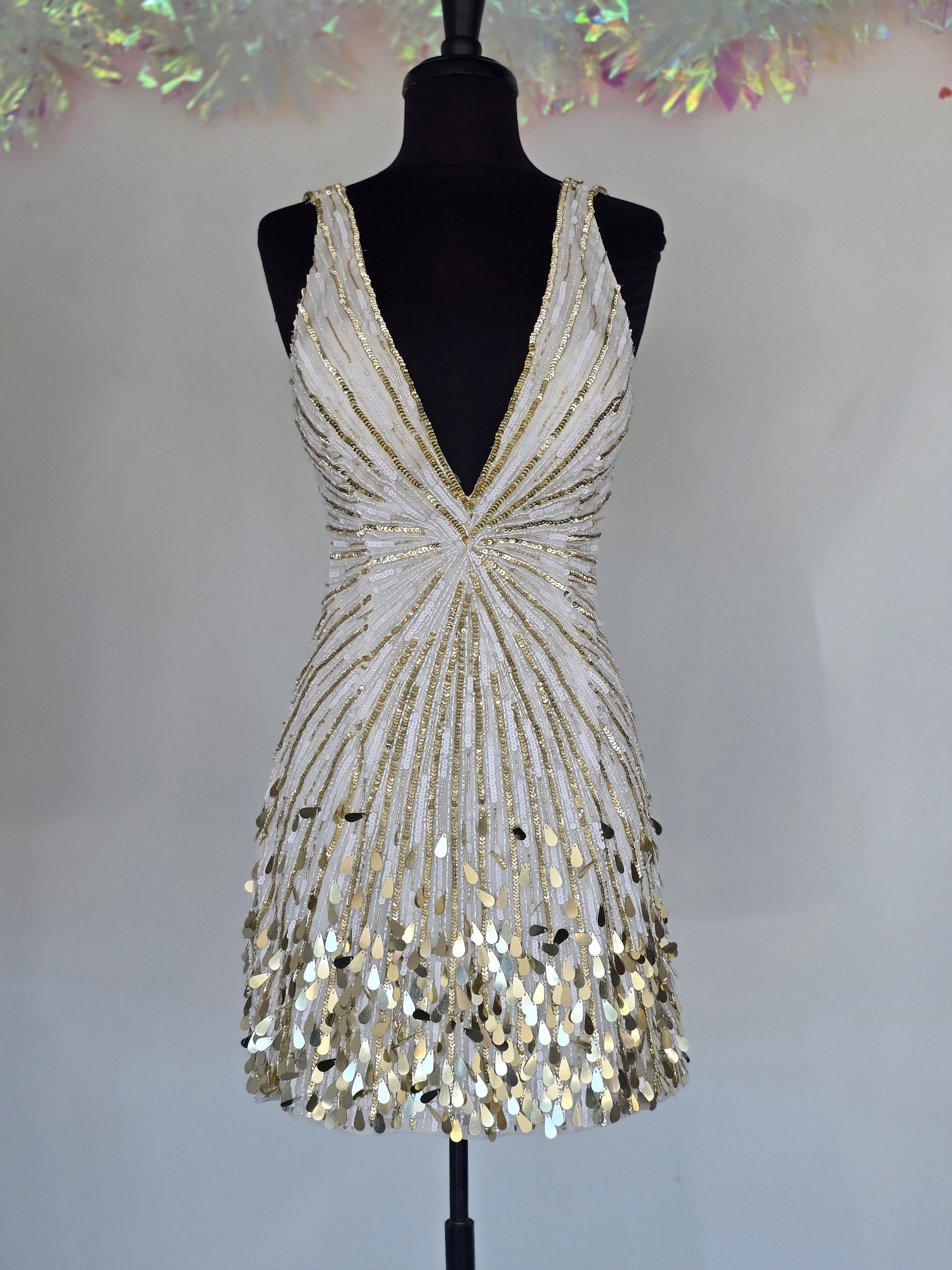 Step into the spotlight with the Primavera Couture 4417, a short backless cocktail gown designed to dazzle. Featuring a flattering V-neck and shimmering sequins, this homecoming dress combines elegance with a playful edge. Its backless design adds a touch of allure, perfect for making unforgettable memories at your special event. Comfortable and stylish, it’s crafted to help you feel confident and radiant all night long.

Sizes: 6

Colors: Ivory/Gold