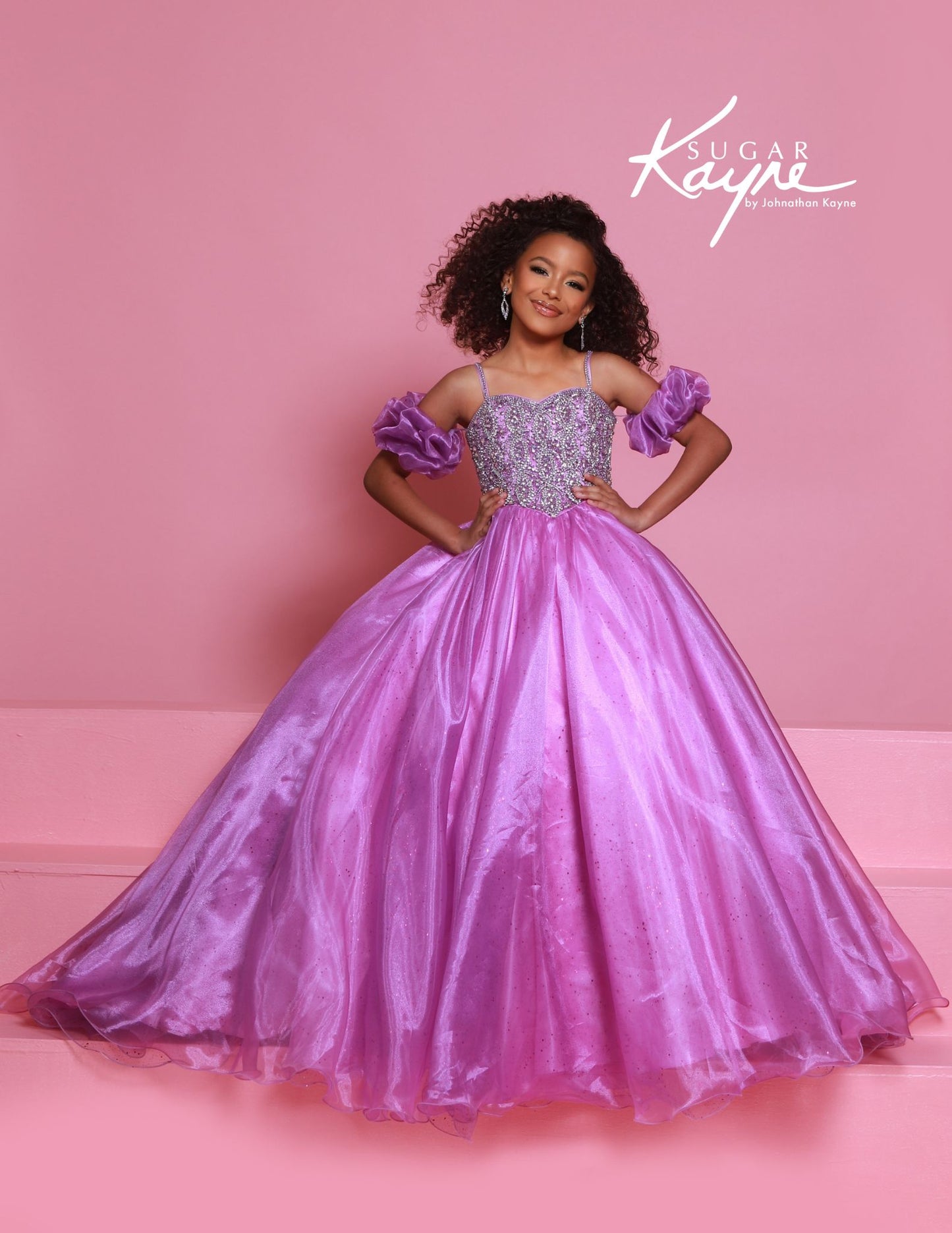 Dazzle on stage with the Sugar Kayne C359 pageant ballgown dress. Featuring a sweetheart neckline, puff sleeves, and spaghetti straps, this dress will make you stand out. With an embellished bodice and a glitter tulle and organza long skirt, you'll sparkle and shine like a true pageant queen.

Colors:&nbsp; Capri Blue, Rose Pink, White, Purple, Red

Sizes:&nbsp; 2-16