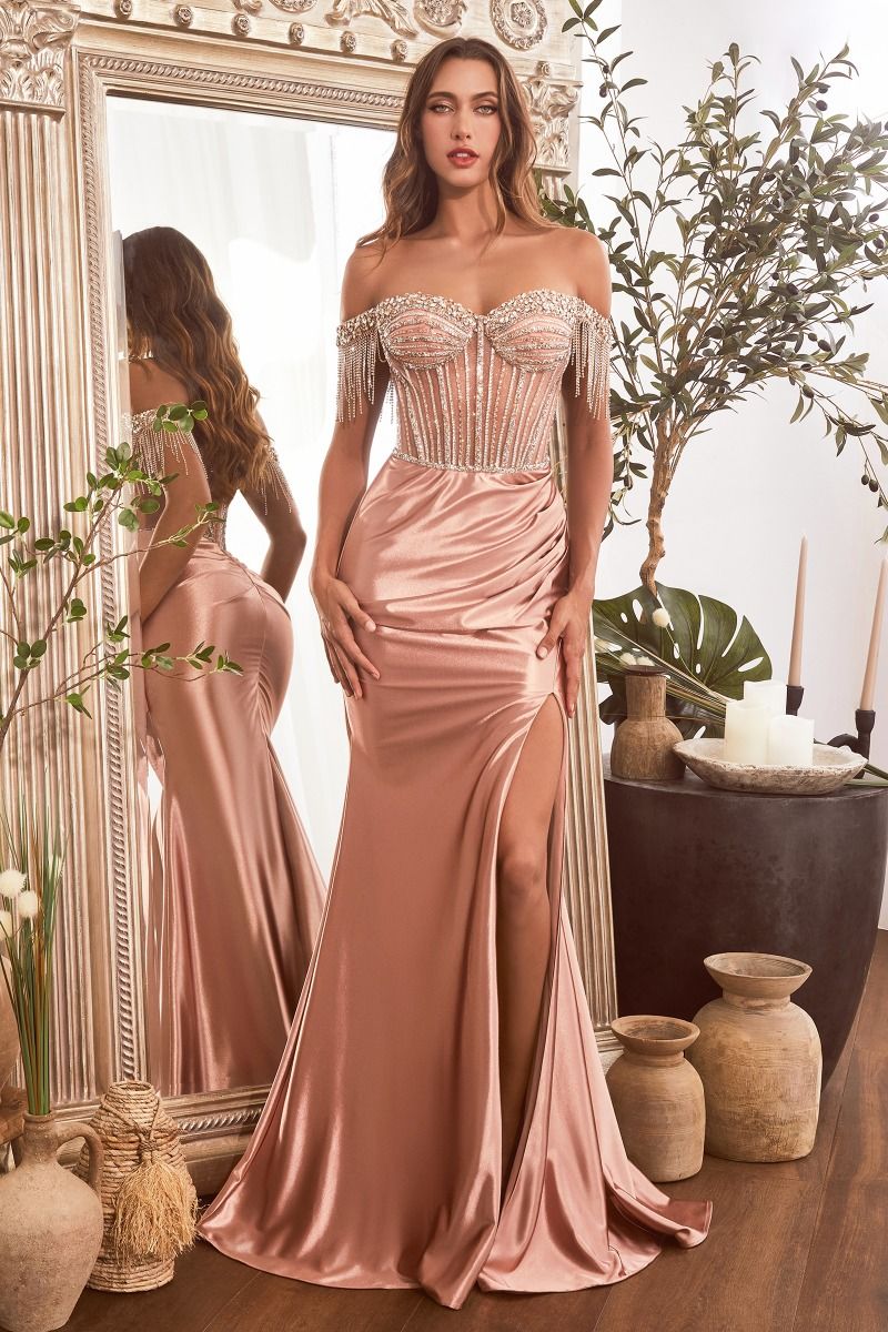 This Ladivine CD821 dress features a sheer off-the-shoulder corset, crystal embellishments, and a satin skirt with a flattering front slit and fringe detailing. Perfect for prom, pageants, or elegant evening events, this dress will make you feel sophisticated and glamorous