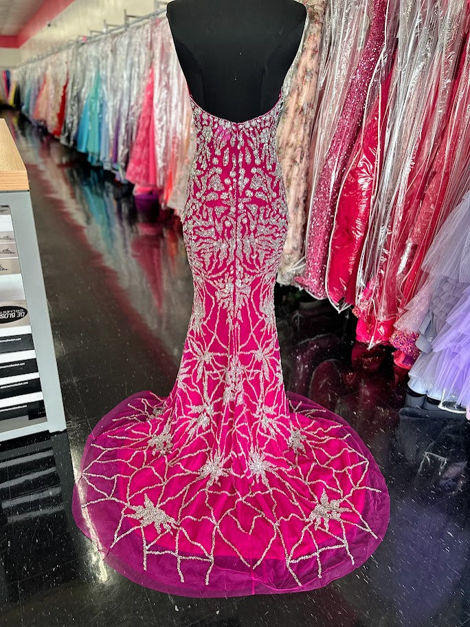 This elegant fuchsia evening gown from Chic and Holland features intricate beadwork that enhances its sophisticated appeal. Designed for formal occasions, the floor-length dress includes a tasteful slit, offering both movement and modern style. Tailored to a size 2, it delivers a flattering silhouette perfect for pageants or upscale events. The combination of refined detailing and vibrant color ensures a standout presence at any formal gathering.

Size: 2

Colors: Fuchsia