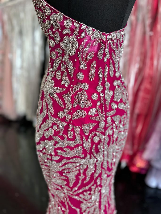 This elegant fuchsia evening gown from Chic and Holland features intricate beadwork that enhances its sophisticated appeal. Designed for formal occasions, the floor-length dress includes a tasteful slit, offering both movement and modern style. Tailored to a size 2, it delivers a flattering silhouette perfect for pageants or upscale events. The combination of refined detailing and vibrant color ensures a standout presence at any formal gathering.

Size: 2

Colors: Fuchsia
