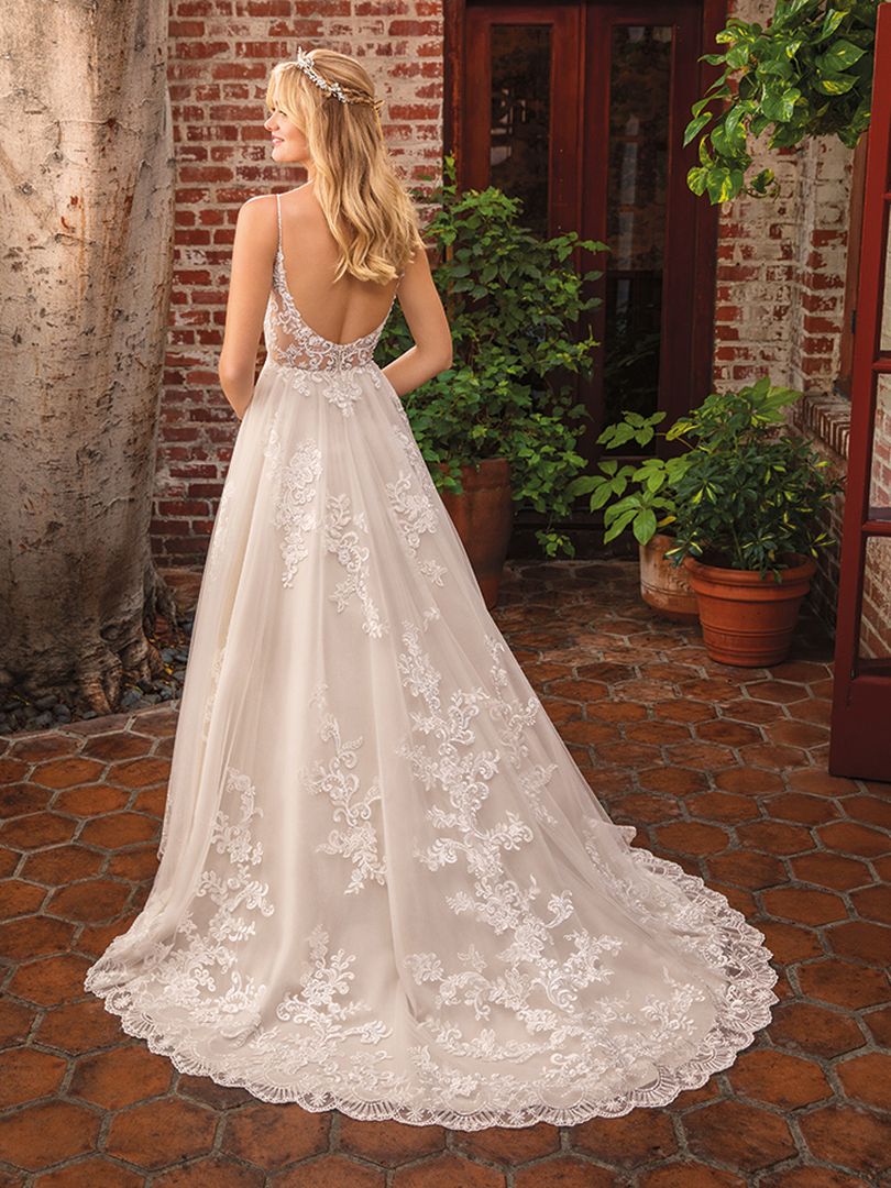 Casablanca Beloved STYLE BL286 DELILAH Other-worldly grace surrounds Delilah, swimming in sateen satin and tulle. Lace appliques cover the bodice and cascade down the flowing skirt of this bohemian wedding gown from Beloved by Casablanca Bridal. Spaghetti straps and a plunging neckline add a seductive touch, transitioning into an alluring illusion lace back. Subtle silver beading catches the light, while a matching veil finishes off this modern boho gown with a glimmer!