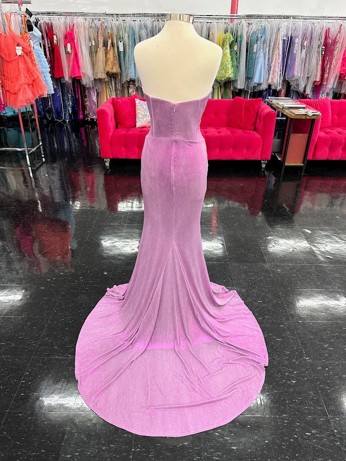Indulge in opulence with the Jovani D5079 Long Fitted Metallic Prom Dress. Featuring a crystal corset bodice, sheer cut outs, and elegant train, this formal gown exudes luxury. With a figure-hugging fit and metallic fabric, this dress is perfect for making a statement at any special occasion.

Sizes: 10

Colors: Lilac
