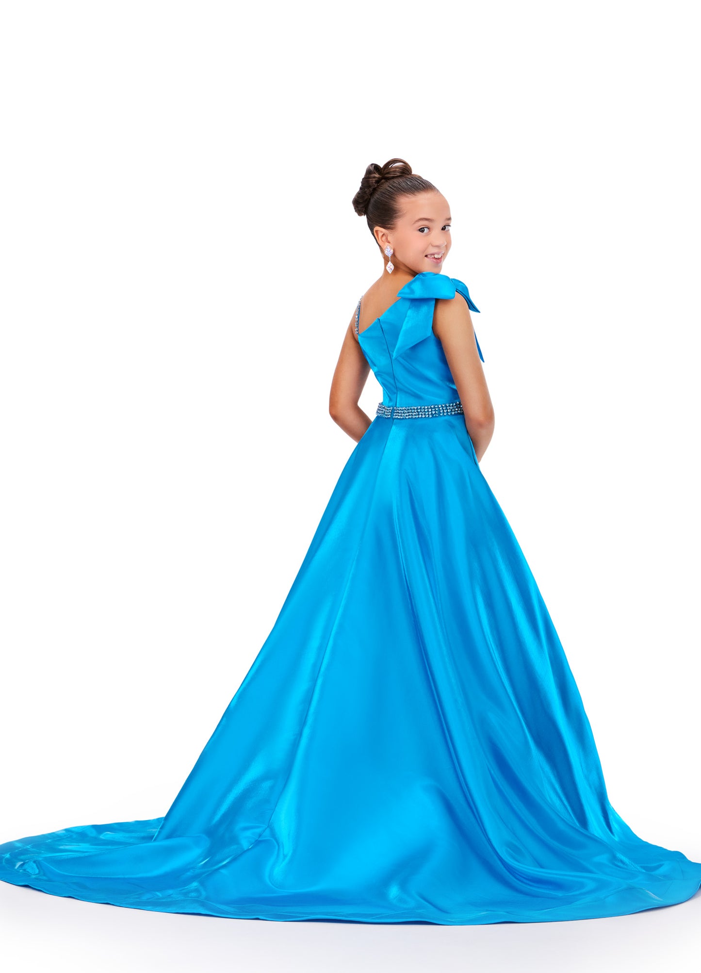Expertly crafted for the pageant stage, the Ashley Lauren Kids 8248 dress is designed with a shimmering satin fabric and a unique one-shoulder bow for a touch of elegance. Its A-line silhouette flatters any figure while making a stunning statement. Perfect for a winning performance. This beautiful satin gown features a one shoulder neckline with bow. The look is complete with a rhinestone belt and full skirt.