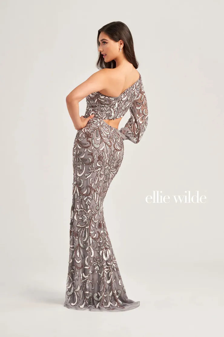 This stunning Ellie Wilde EW35020 prom dress features a one shoulder design with long puff sleeve, detailed with sequins and beading. The beaded cut out adds a touch of glamour to this elegant formal gown. Perfect for any special occasion, this dress will make you stand out from the crowd.  Sizes: 00-16  Colors: Gray/Bronze, Navy Blue