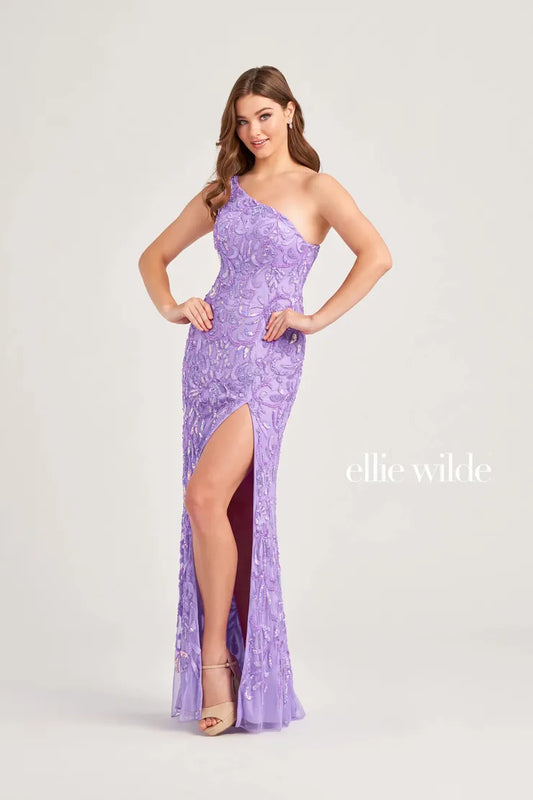 Expertly crafted by Ellie Wilde EW35021, this one shoulder prom dress is sure to make a statement. The intricate beaded and sequin detailing adds just the right amount of sparkle, while the slit provides a touch of elegance. Perfect for any formal occasion, this gown is designed to stand out.  Sizes: 00-16  Colors: Lavender, Red, Royal Blue