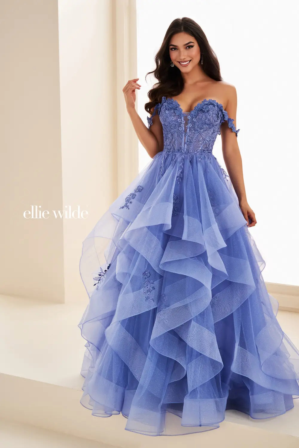 Make a statement in the Ellie Wilde EW35084 prom dress. Featuring an off-the-shoulder top, shimmer sequin lace and ruffle detail, the dress offers a timeless and sophisticated look perfect for the big night. Keep it classic in this classic formal gown.

Sizes: 00-24

Colors: Bluebell, Diamond White, Dusty Rose/Gold, Emerald, Hot Pink, Lavender, Light Pink, Light Yellow, Navy, Red, Royal, Silver, Teal, Wine&nbsp;