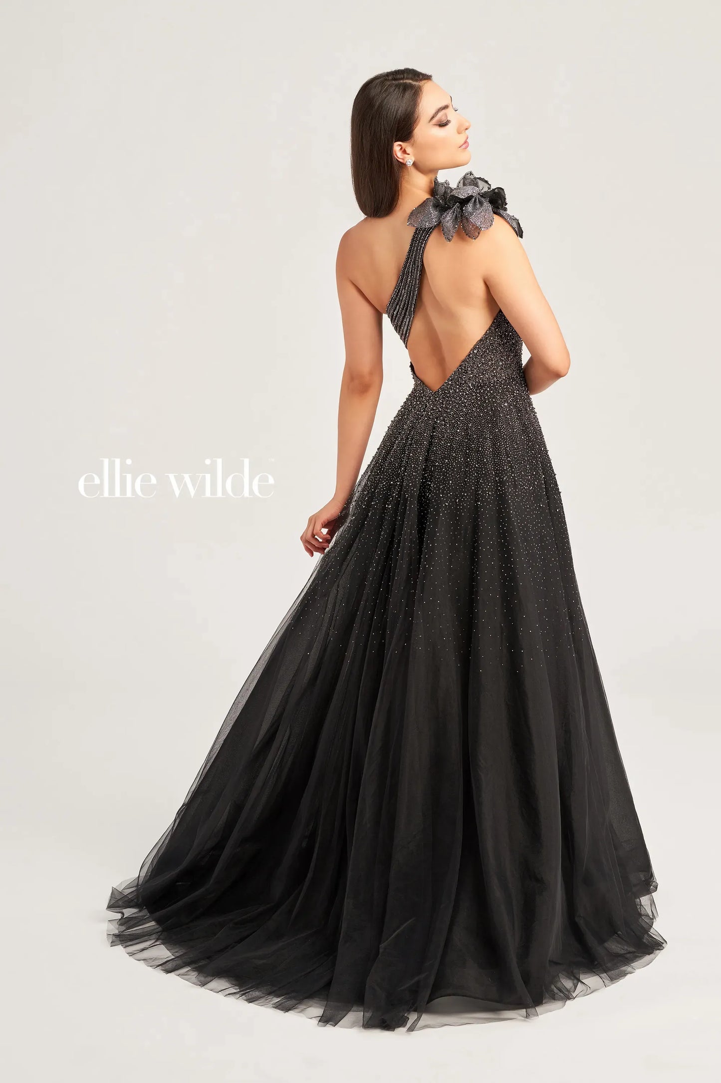 The Ellie Wilde EW35086 Dress boasts a stunning one shoulder cut out design adorned with intricate beading and a bow detail. Its ballgown silhouette, paired with a maxi slit, creates a dramatic and elegant look. Perfect for formal events, this dress is sure to make a lasting impression.  Sizes: 00-16  Colors: Misty Blue, Black/Gunmetal