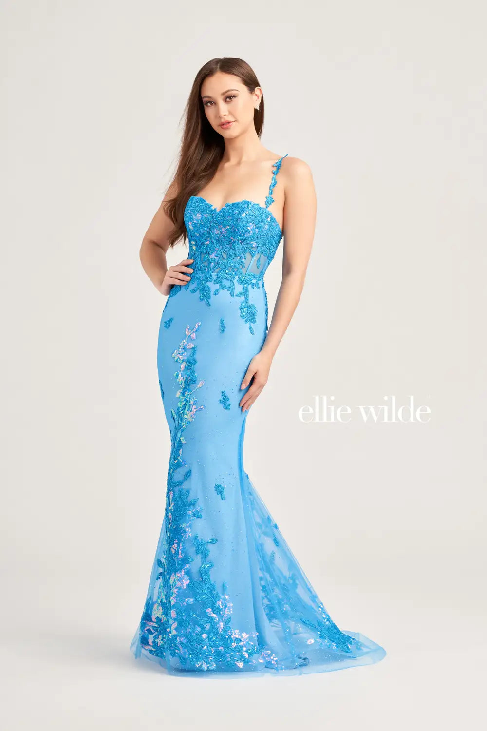Be the center of attention in the Ellie Wilde EW35207 prom gown. Featuring a stunning lace sequin bodice with sheer corset detailing and a detachable side overskirt for added drama, this dress is perfect for pageants and prom. Turn heads and feel like a queen with this elegant and eye-catching dress.  Sizes: 00-16  Colors: Sage, Ocean Blue