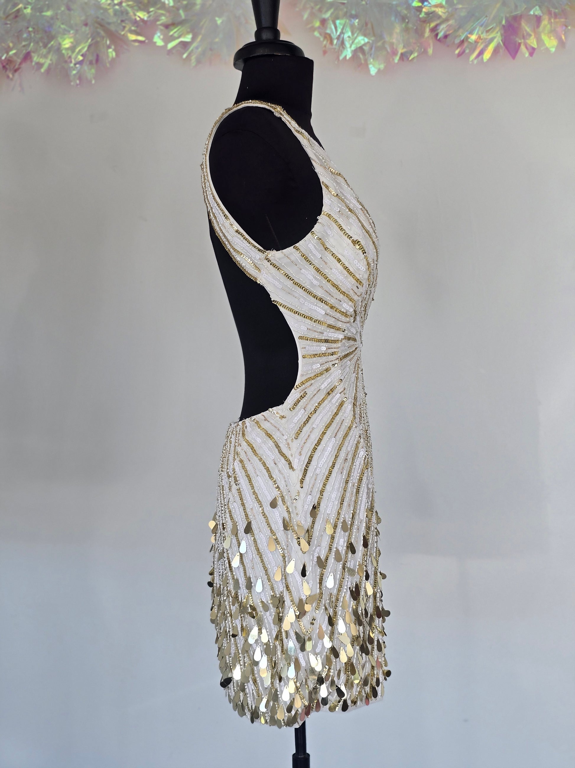 Step into the spotlight with the Primavera Couture 4417, a short backless cocktail gown designed to dazzle. Featuring a flattering V-neck and shimmering sequins, this homecoming dress combines elegance with a playful edge. Its backless design adds a touch of allure, perfect for making unforgettable memories at your special event. Comfortable and stylish, it’s crafted to help you feel confident and radiant all night long.

Sizes: 6

Colors: Ivory/Gold