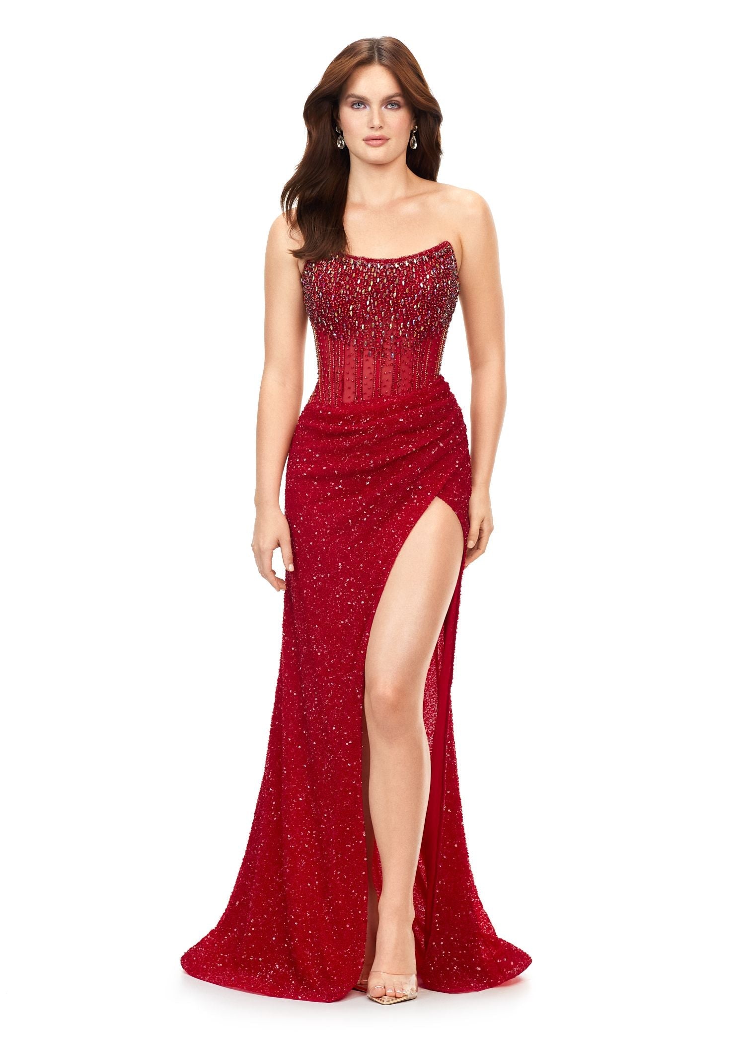 Ashley Lauren 11238 Feel like a celebrity in this jaw-dropping strapless dress. This fitted evening gown has stunning crystal beadwork on the bodice and is paired with a decadent fully beaded wrap skirt. Strapless Corset Bustier Wrap Skirt Left Leg Slit Colors:  Nude, Red