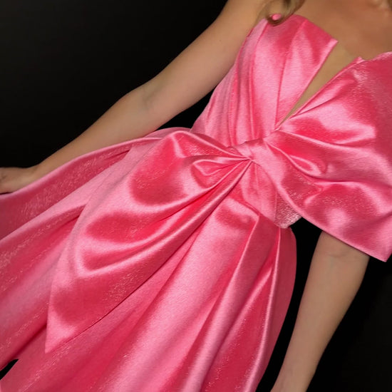 Elevate your formal occasion with the Ashley Lauren 4816 cocktail dress, featuring a flattering short fit and flared silhouette. The elegant pleated design is complemented by an oversized bow, adding a refined touch to the V-neck neckline. Perfect for homecoming or any special event, this dress combines classic sophistication with modern charm for a truly memorable look. ASHLEYlauren Style 4816 is a short Mikado dress that combines playful charm with bold sophistication. Featuring a structured bodice and ov