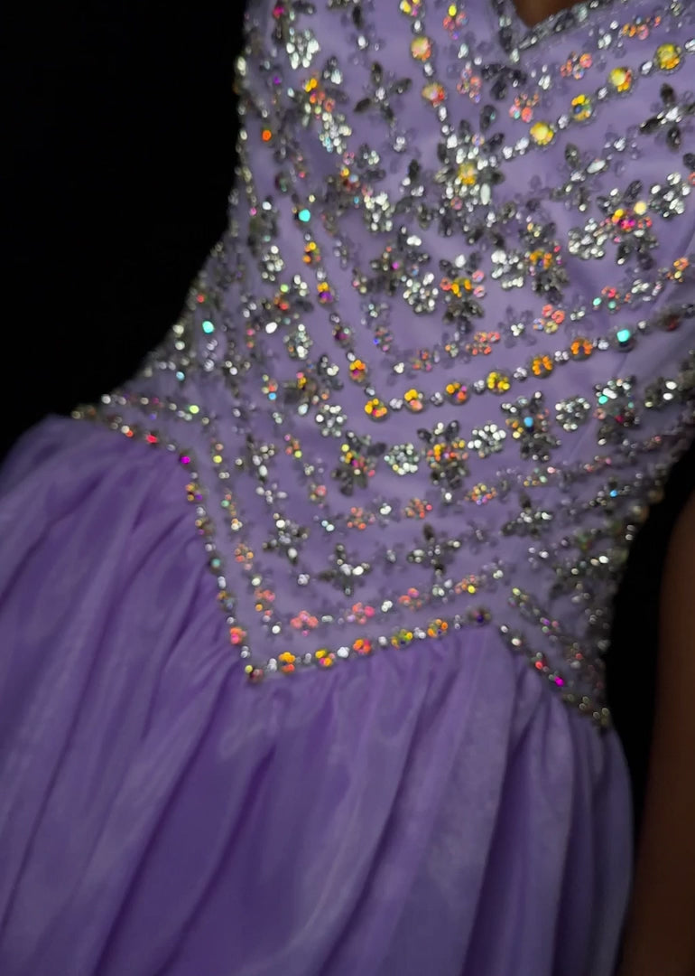 Ashley Lauren 12047&nbsp; Make a grand entrance with ASHLEYlauren Style 12047, an exquisite organza ball gown featuring a fully beaded fitted bodice and a voluminous flowing skirt. Available in Orchid, Red, Ivory, and Royal, this gown is perfect for proms, pageants, and formal events.