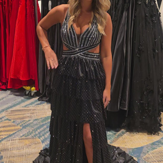 Nina Canacci's 9200 is a show-stopping pageant gown that combines elegance with contemporary flair. The crystal-layered jersey skirt features intricate micro crystal embellishments that catch light beautifully, while strategic side cutouts add modern sophistication. A dramatic maxi slit and flowing train create movement and grandeur, making this dress ideal for prom, pageants, and formal competitions. The jersey construction ensures comfortable wear throughout the evening while maintaining a polished silhou