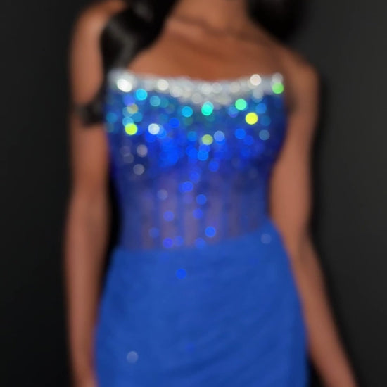 This Ashley Lauren 4856 dress features a short, fitted silhouette with a sheer corset bodice adorned with delicate crystal embellishments. The scoop neckline adds a graceful touch, making it an elegant choice for homecoming or cocktail events. Its refined design combines modern allure with timeless sophistication. Make a dazzling entrance in the ASHLEYlauren Style 4856, a strapless beaded mini dress featuring a gradient design that transitions from sparkling silver to deep black at the bodice, paired with a