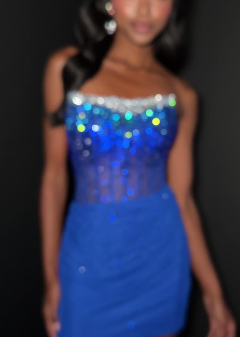 This Ashley Lauren 4856 dress features a short, fitted silhouette with a sheer corset bodice adorned with delicate crystal embellishments. The scoop neckline adds a graceful touch, making it an elegant choice for homecoming or cocktail events. Its refined design combines modern allure with timeless sophistication. Make a dazzling entrance in the ASHLEYlauren Style 4856, a strapless beaded mini dress featuring a gradient design that transitions from sparkling silver to deep black at the bodice, paired with a