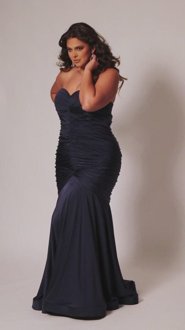 Make a statement in this luxurious Sydneys Closet SC7374 prom dress. This long, fitted gown is crafted in a mermaid silhouette, with a strapless neckline, ruching from the waistline to the floor, and a statement train. Perfect for plus size formal occasions. Look glamorous at Prom 2024 or any dressy event when you wear our Simply Ravishing plus size formal Mermaid gown. 