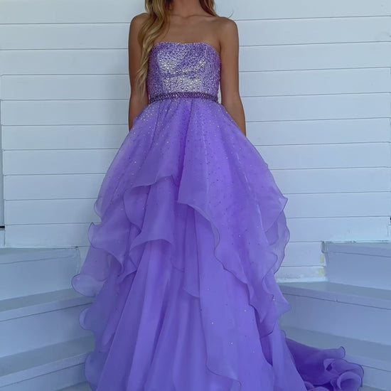 Add a touch of elegance to any formal event with the Ava Presley 39561 Long Prom Dress. The beaded bodice and halter top provide a dazzling look, while the crystal belt-line and layered ruffles add texture and movement. Perfect for prom, pageants, or any special occasion.