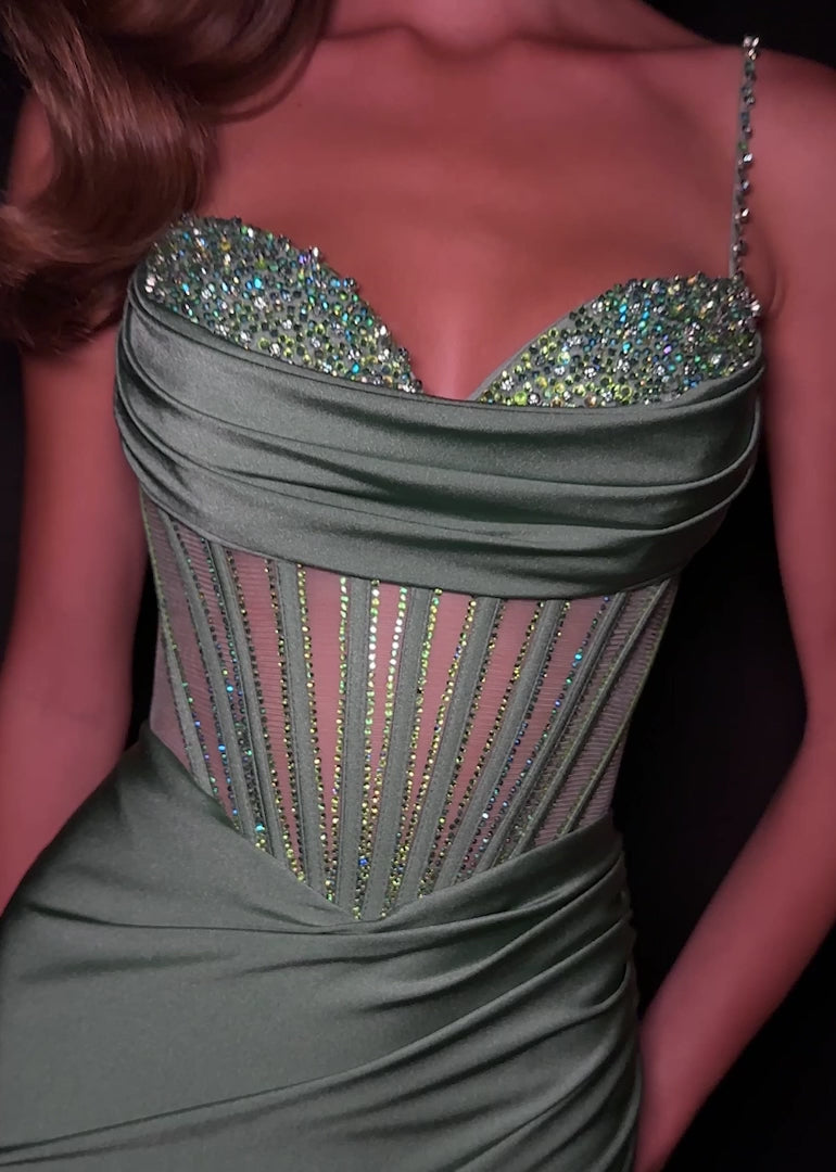 Step into sophistication with this sleek and elegant jersey gown, ASHLEYlauren Style 12173. Featuring a beaded bustier-style bodice with delicate spaghetti straps, this fitted dress highlights your figure with a ruched waist and flattering draped skirt. The corset detailing adds structure and sparkle, while the sweeping train ensures a glamorous finish. Perfect for prom, pageant, or any formal event, this gown brings modern allure and timeless elegance together.

Available in Emerald, Purple, Red, Black, Fu
