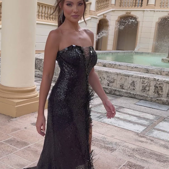 Dazzle in the Ava Presley 28573 Long Prom Dress. This stunning gown features intricate beading, a cut glass detail, and a dramatic high slit. The feather trim adds a touch of elegance to this formal pageant dress. Elevate your look and make a statement at your next event.