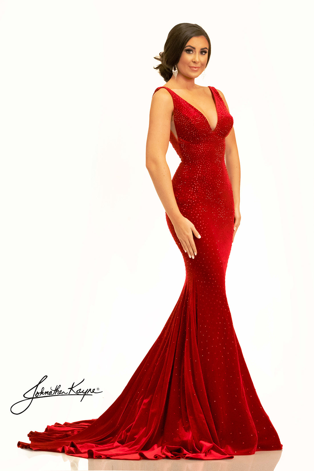 The Johnathan Kayne 2308 Long Velvet Crystal Pageant Dress is the perfect choice for a formal event. This stunning prom gown features a V-neck train and is embellished with exquisite crystals for a look that is sure to dazzle. With its high-quality velvet fabric, you'll have no trouble making a statement. This head to toe crystal shimmering stretch velvet dress is sure to be a winner. 
