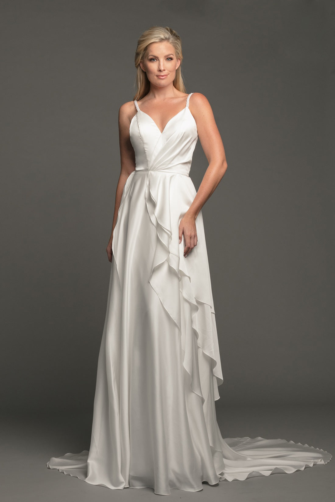 Make your entrance in Johnathan Kayne's B114 Size 8 Ivory Charmeuse Ruffle Destination Wedding Dress. This exquisite bridal gown showcases a beaded strap bodice, airy ruffle skirt, and ivory charmeuse material that will flatter your figure. Perfect for a formal or destination wedding, it's the perfect gown you need to look and feel amazing.  Size: 8  Color: Ivory