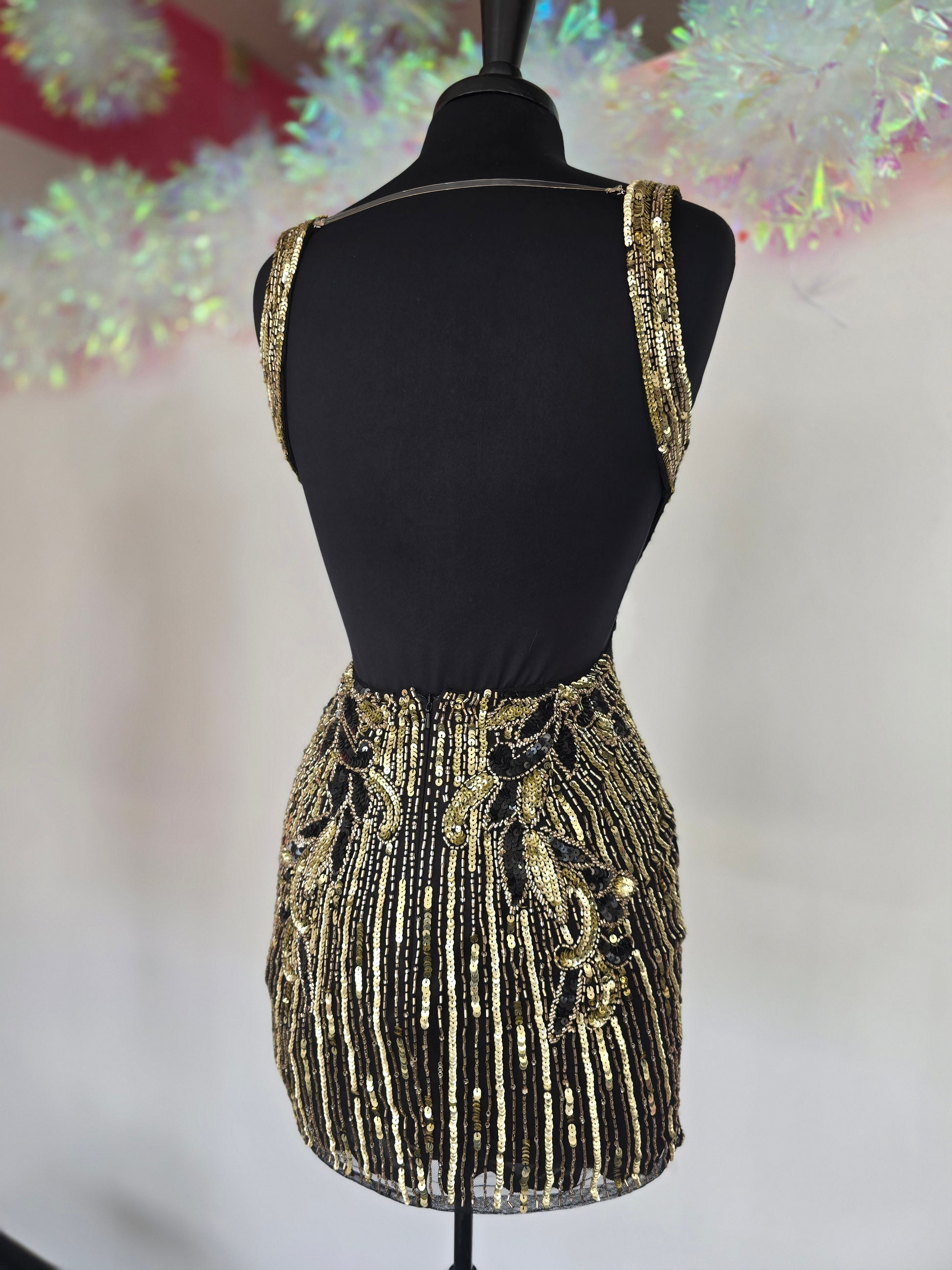 Make a stunning entrance with the Primavera Couture 4408, a short backless homecoming dress adorned with intricate beading and shimmering sequins. Its flattering V-neckline enhances your silhouette, while the backless design adds a touch of bold elegance. Perfect for cocktail events and special occasions, this gown combines glamour and comfort to help you feel confident and radiant all night long.

Sizes: 4

Colors: Black/Gold