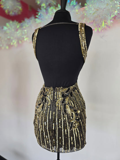 Make a stunning entrance with the Primavera Couture 4408, a short backless homecoming dress adorned with intricate beading and shimmering sequins. Its flattering V-neckline enhances your silhouette, while the backless design adds a touch of bold elegance. Perfect for cocktail events and special occasions, this gown combines glamour and comfort to help you feel confident and radiant all night long.

Sizes: 4

Colors: Black/Gold