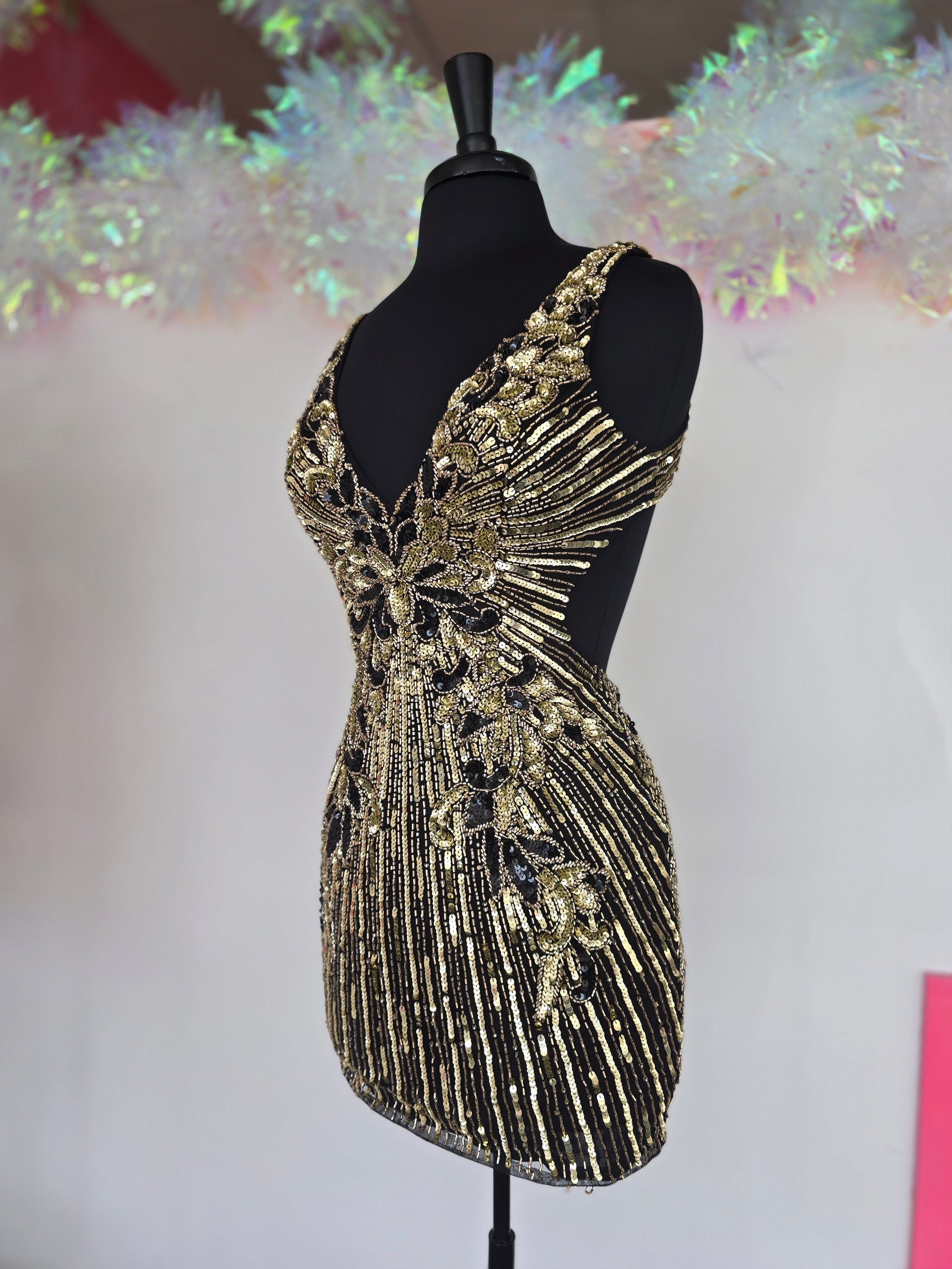 Make a stunning entrance with the Primavera Couture 4408, a short backless homecoming dress adorned with intricate beading and shimmering sequins. Its flattering V-neckline enhances your silhouette, while the backless design adds a touch of bold elegance. Perfect for cocktail events and special occasions, this gown combines glamour and comfort to help you feel confident and radiant all night long.

Sizes: 4

Colors: Black/Gold