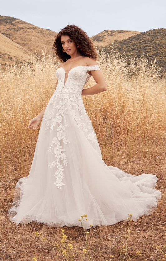 Casablanca Beloved BL433 A-Line Floral Lace Deep V-Neck Off The Shoulder Tulle Train Wedding Gown. Penny’s A-line silhouette defines her feminine form, perfectly subtle yet flattering on any size and shape. A symphony of floral lace appliques flow from her bodice, trailing down into her flattering A-line skirt
