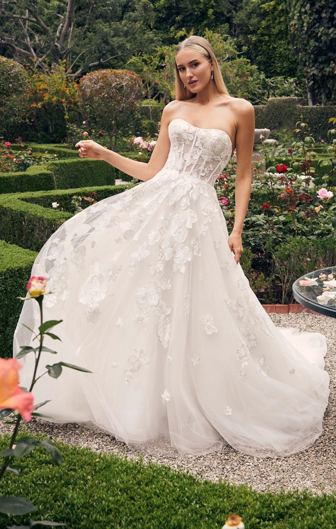 Casablanca Bridal 2540 Elloise A-Line Ballgown Strapless Sheer Floral Corset Sweetheart Neckline Open Back Train Wedding Gown. Prepare to be swept away by the ethereal beauty of Style 2540 Elloise, our exquisite A-line wedding dress. The strapless modified sweetheart neckline exudes romance and sophistication, beautifully framing your face and shoulders.