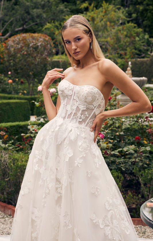 Casablanca Bridal 2540 Elloise A-Line Ballgown Strapless Sheer Floral Corset Sweetheart Neckline Open Back Train Wedding Gown. Prepare to be swept away by the ethereal beauty of Style 2540 Elloise, our exquisite A-line wedding dress. The strapless modified sweetheart neckline exudes romance and sophistication, beautifully framing your face and shoulders.