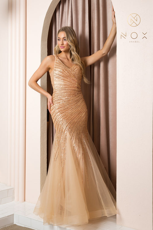 The Nox Anabel H1088 long fitted sequin beaded gold mermaid prom dress offers an elegant and timeless look for special occasions. Crafted with quality in mind, this gown features an exquisite gold sequin beaded bodice and an eye-catching open back design, making it perfect for pageants and other red carpet events. With a form-fitting silhouette and subtle sheer mesh detailing, this captivating dress is sure to make a statement.  Sizes: 4-16  Colors: Gold 