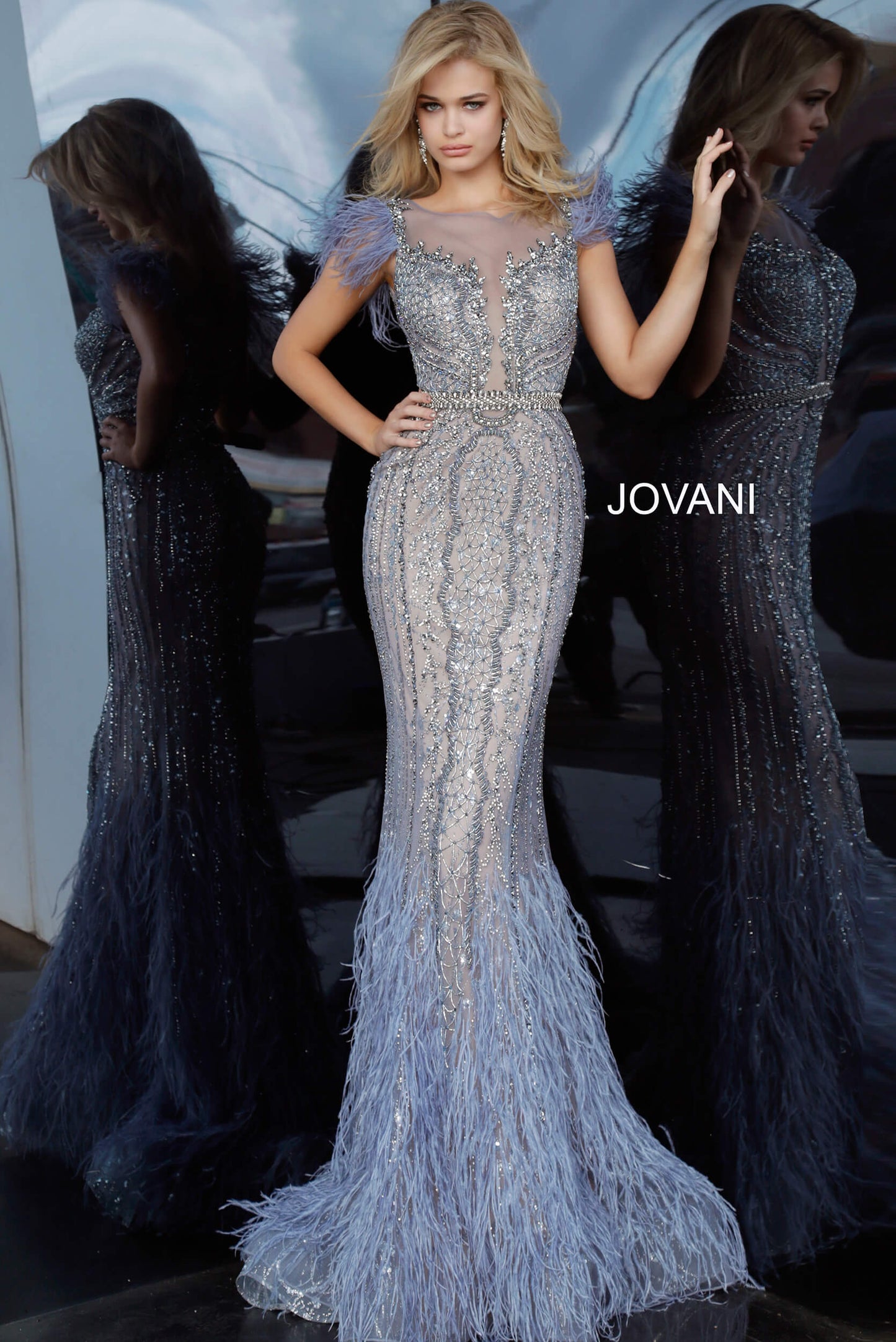 Jovani Couture 02326 is a long fitted Formal Evening Gown Great For Pageants, Red Carpet Events, Event Guests & More! Fit & Flare Mermaid silhouette with a sheer Illusion high neckline with a plunging effect with mesh trimmed in Embellishments that cascade into the bodice. Hand Beaded with sequin, liquid beading, Beaded Fringe tassels & rhinestones. Vintage blue embellished evening dress with a sheer illusion boat neckline, feather trim cap sleeves, beaded waist belt and closed sheer back.